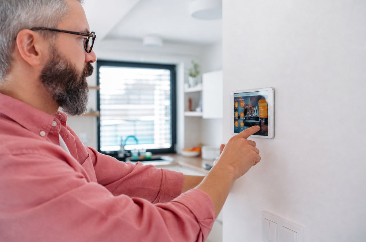 Hombre configurando el panel de una alarma en casa